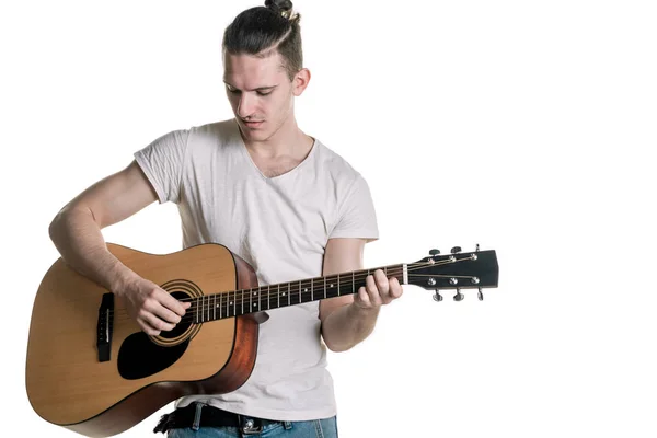 Музика та творчість. Красивий молодий чоловік у футболці грає на акустичній гітарі. Горизонтальна рамка — стокове фото