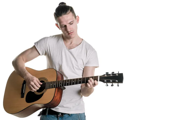 Música e criatividade. Um jovem bonito de t-shirt a tocar guitarra acústica. Quadro horizontal — Fotografia de Stock