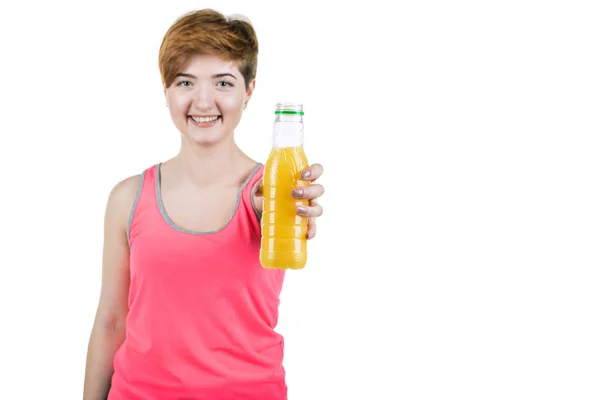 Здоровый образ жизни, здоровое питание. Молодая девушка с бутылкой апельсинового сока в руке, улыбаясь, на белом изолированном фоне. Горизонтальная рамка — стоковое фото