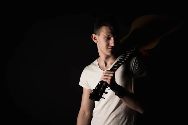 Música e criatividade. Um jovem bonito de t-shirt a tocar guitarra acústica. Quadro horizontal — Fotografia de Stock