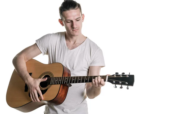 Zene és a kreativitás. Jóképű fiatalember póló akusztikus gitáron játszik. Vízszintes keret — Stock Fotó