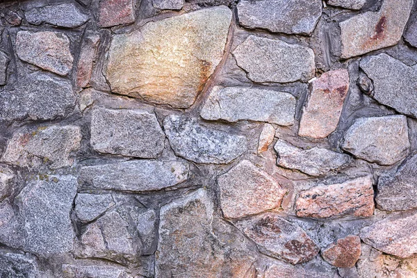 Background. The texture of the wall is from multi-colored wild stones to the whole frame. Horizontal frame Stock Photo