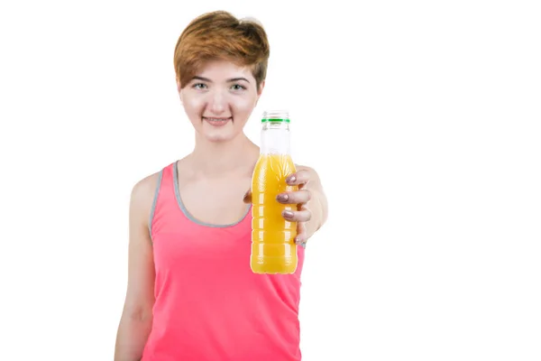 Здоровый образ жизни, здоровое питание. Молодая девушка с бутылкой апельсинового сока в руке, улыбаясь, на белом изолированном фоне. Горизонтальная рамка — стоковое фото
