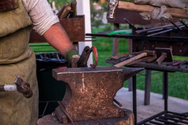 İki demirci örs yakınındaki. Bir at nalı bir jambon ile kesmek