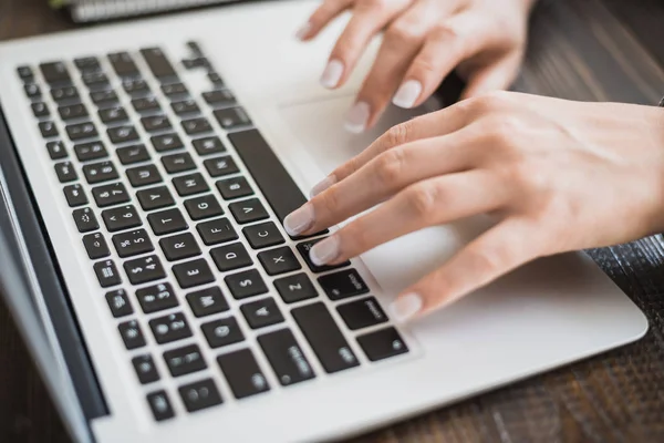 Work of a business lady. Female hands working on a modern laptop. On a wooden table. Horizontal frame — Stock Photo, Image