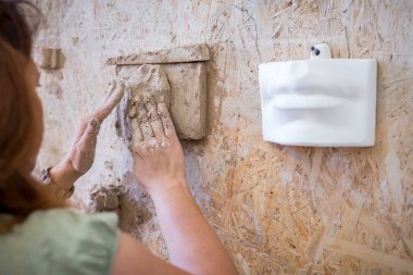 Bir heykeltraş ağzını heykeli sculpts. Yatay Çerçeve