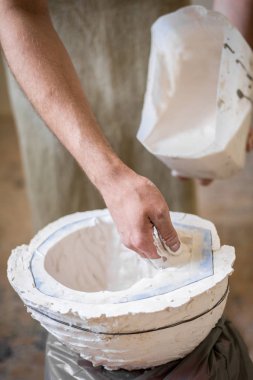 Heykeltıraşın elinde beyaz sıvı kalıp içine doldurun. Dikey Çerçeve