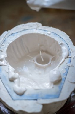 Heykeltıraşın elinde beyaz sıvı kalıp içine doldurun. Dikey Çerçeve