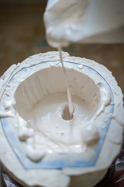 Las manos del escultor llenan el líquido blanco en el molde. Marco vertical — Foto de Stock