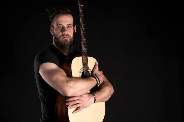 孤立した黒地にアコースティック ギターとひげを持つカリスマ的でスタイリッシュな男立つフルレングス. — ストック写真