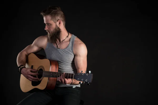 ひげを持つカリスマ的な男は、アコースティック ・ ギター、黒い背景を分離しました。水平フレーム — ストック写真