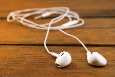 Ahşap izole arka plan üzerinde beyaz küçük kulaklıklar. Yatay Çerçeve