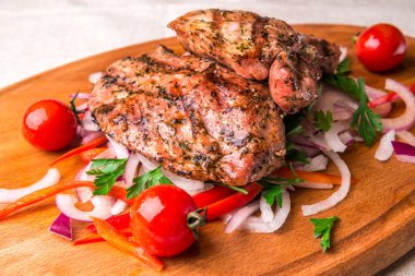 İştah açıcı kızarmış tavuk uyluk, domates ve soğan ile dekore edilmiştir. Yatay Çerçeve