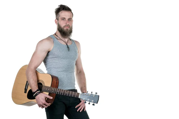 Um homem carismático com barba segura uma guitarra acústica, sobre um fundo branco isolado. Quadro horizontal — Fotografia de Stock