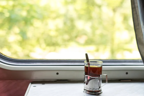 Travel, rest. Hot tea in a glass cup, in a train. Horizontal frame — Stock Photo, Image