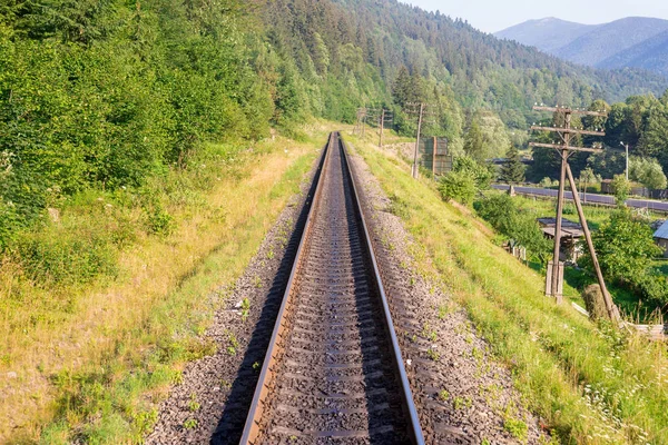 Reisen, Ruhe. Blick auf die Bahngleise, umgeben von Bäumen, Gras und Büschen. horizontaler Rahmen — Stockfoto