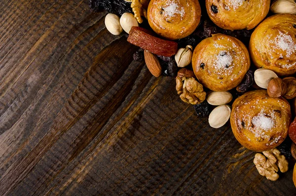 Nozes, frutas secas, pistácios e biscoitos caseiros espalhados do saco sobre a mesa com um lugar para escrever — Fotografia de Stock