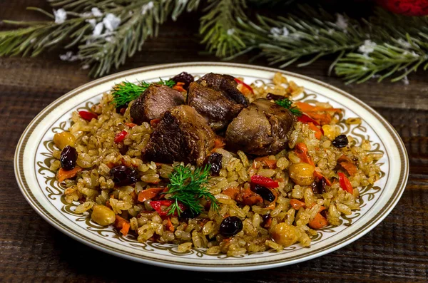 Uzbek national pilaf dish on a dark wooden background with Chris — Stock Image Uzbek national pilaf dish on a dark wooden background with Chris Royalty Free Stock Photos
