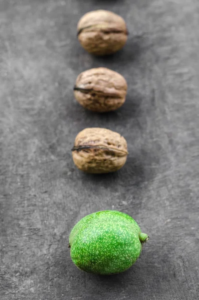 Tres nueces peladas texturizadas y una mentira verde en una línea — Foto de Stock