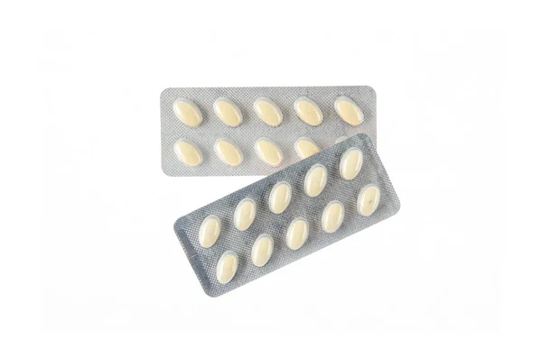 Twee platen voor gele tabletten op witte geïsoleerde achtergrond — Stockfoto