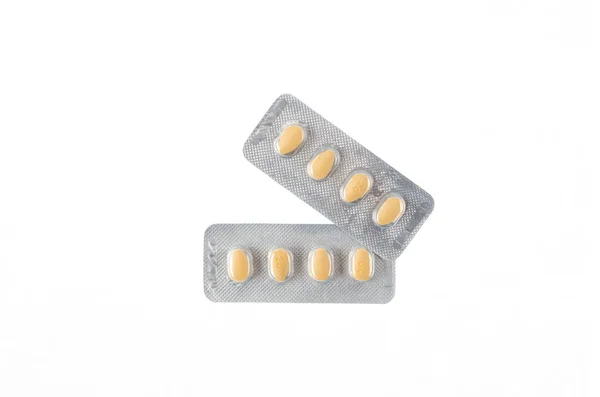 Twee platen voor gele tabletten op witte geïsoleerde achtergrond — Stockfoto