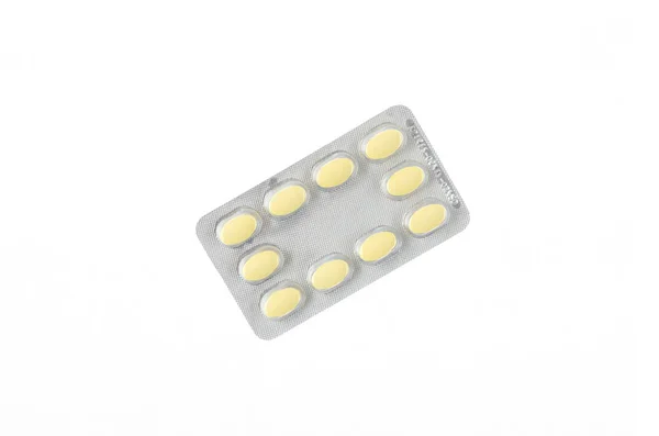 Een plaat van gele pillen op een witte achtergrond voor geïsoleerde — Stockfoto
