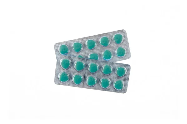 Twee platen van groene pillen op witte geïsoleerde achtergrond — Stockfoto