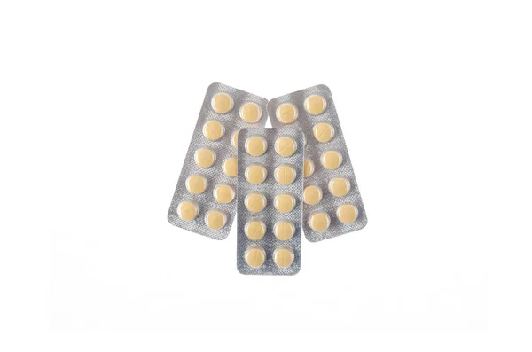 Три тарелки желтых таблеток на белом изолированном фоне — стоковое фото