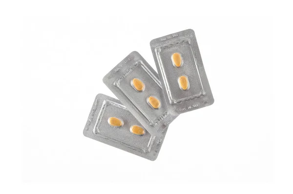 Drie platen van gele pillen op witte geïsoleerde achtergrond — Stockfoto