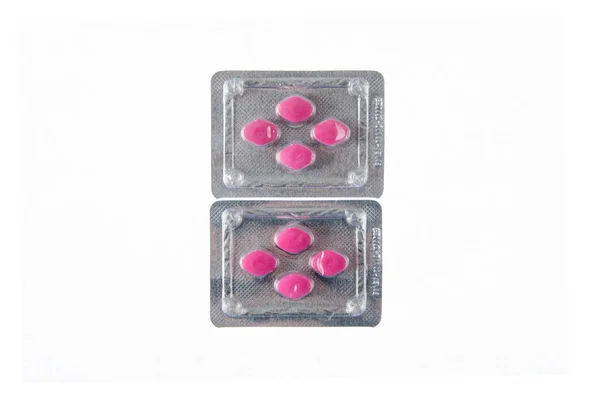 Twee platen van rode pillen op witte geïsoleerde achtergrond — Stockfoto