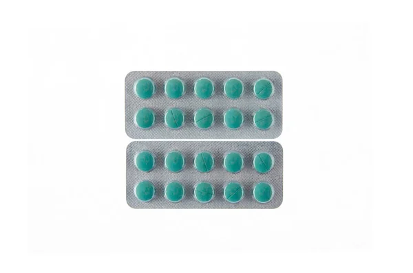 Две тарелки зеленых таблеток на белом изолированном фоне — стоковое фото