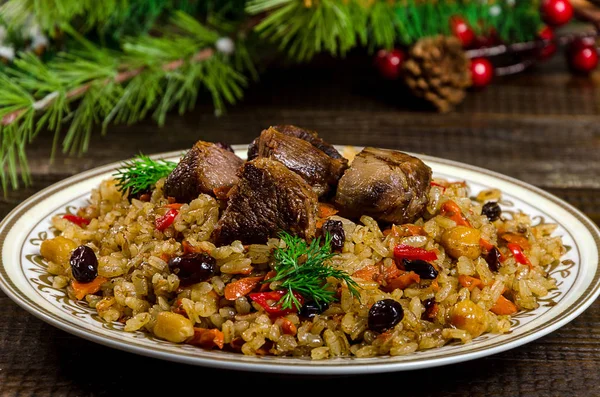Uzbek national pilaf dish on a dark wooden background with Chris — Stock Image Uzbek national pilaf dish on a dark wooden background with Chris Stock Picture
