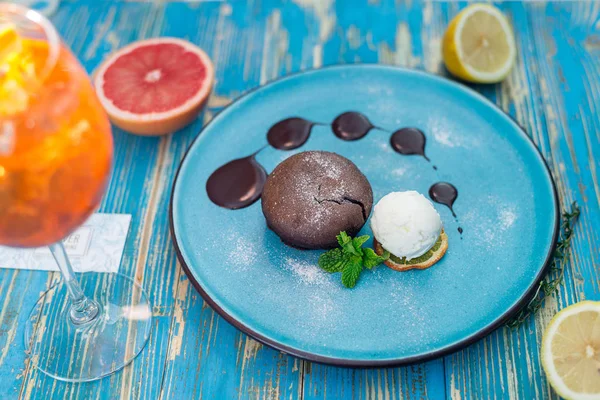 Torta al cioccolato con una pallina di gelato bianco su un piatto blu — Foto Stock