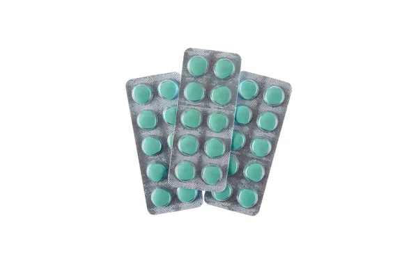 Три тарелки зеленых таблеток на белом изолированном фоне — стоковое фото
