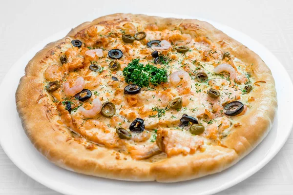 Круглая пицца на белой тарелке — стоковое фото