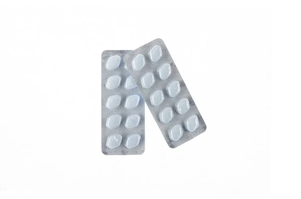 Две тарелки синих таблеток на белом изолированном фоне — стоковое фото