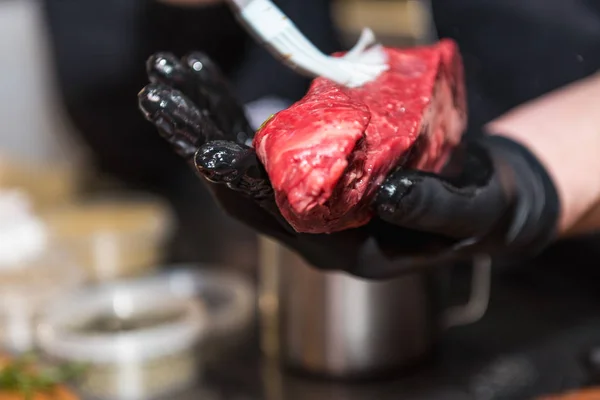 Les mains du chef lubrifient la viande crue — Photo