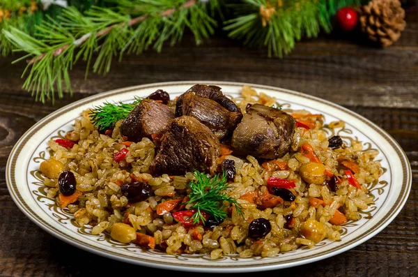 Uzbek national pilaf dish on a dark wooden background with Chris — Stock Image Uzbek national pilaf dish on a dark wooden background with Chris Royalty Free Stock Images