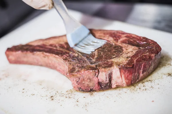 Le cuisinier coupe la viande crue — Photo