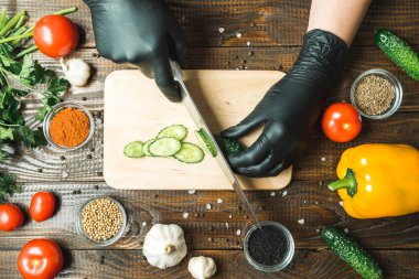 kadınların elleri bir salatalık, domates, kırmızı biber ve sarımsak yakın kesme