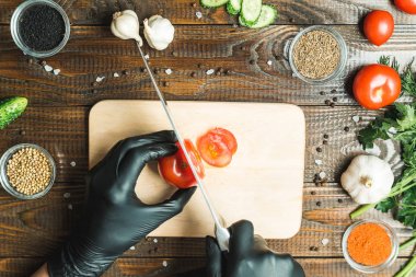 kadınların elleri kesilmiş yalan biber yanındaki bir domates, otlar, salatalık ve baharatlar