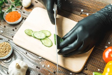 kadınların elleri bir salatalık, domates, kırmızı biber ve sarımsak yakın kesme