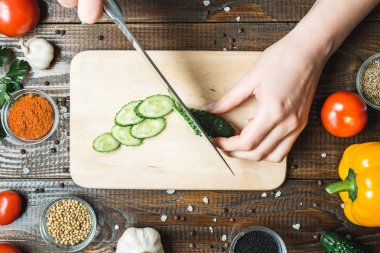 kadınların elleri bir salatalık, domates, kırmızı biber ve sarımsak yakın kesme