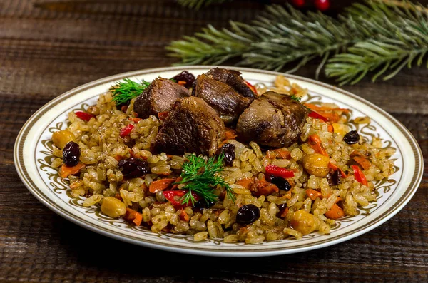 Uzbek national pilaf dish on a dark wooden background with Chris — Stock Image Uzbek national pilaf dish on a dark wooden background with Chris Stock Image