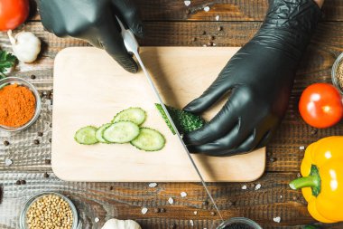 kadınların elleri bir salatalık, domates, kırmızı biber ve sarımsak yakın kesme