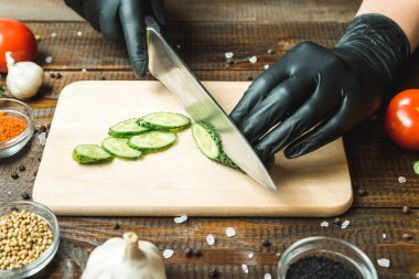 kadınların elleri bir salatalık, domates, kırmızı biber ve sarımsak yakın kesme