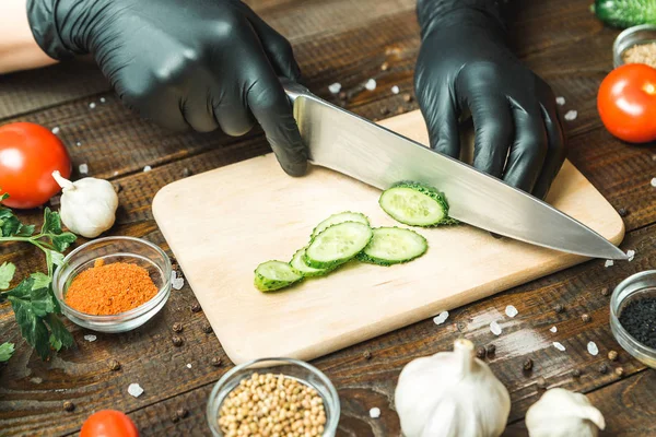 kadınların elleri bir salatalık, domates, kırmızı biber ve sarımsak yakın kesme