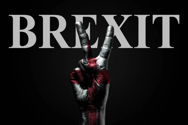On a hand with a painted flag of England and the word BREXIT, on a dark background is a peace sign, a symbol of peace, friendship, greeting and peacefulness. — Stock Photo, Image