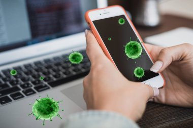 Kadın elleri, koronavirüsün uçan bakterilerinin arka planına karşı akıllı telefon tutar. Karantina Tehlike Yatay Çerçevesi
