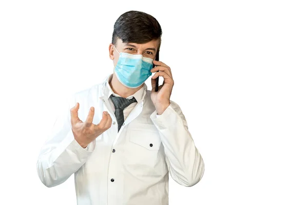 Młody Lekarz Białym Płaszczu Masce Wirusa Rozmawia Przez Telefon — Zdjęcie stockowe